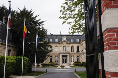 Reims, Fransa - Nisan 2021 - Henry Vasnier Bulvarı 'nda lüks, gastronomik bir restoran ve beş yıldızlı bir otele ev sahipliği yapan Crayeres Estate' in girişinde Fransız, Belçika ve Hollanda bayrakları 