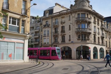 Reims, Fransa - Haziran 2021 - Vezir Sokağı, Cours Jean-Baptiste Lenglet ve Carnot sokağının köşesinde, şehrin tarihi merkezinde pembe bir Citura Alstom hafif treni dönüyor.