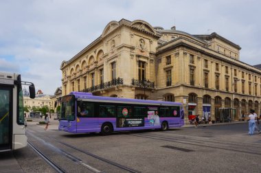 Reims, Fransa - Haziran 2021 - İki Citura şehir otobüsü tarihi şehir merkezindeki iki ana cadde olan Rue Chanzy ve Rue de Vesle 'nin köşesinde, Opera binasının önünde karşıdan karşıya geçiyor.