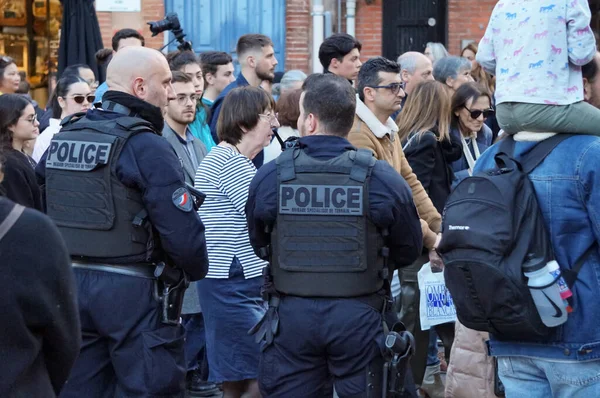 Toulouse, Fransa - Şubat 2023 - Saint-Cyprien Meydanı 'nda emekli aylığı reformunu protesto eden ve taktik yelek giyen üç silahlı polis memurundan oluşan bir grup
