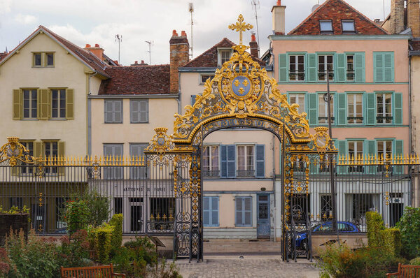 Troyes, France - Sept. 2020 - Ancient, traditional townhouses in Rue de la Cit, a typical old street in the historic center, in front of the 18th century gilded gate of the Hotel-Dieu-Le-Comte