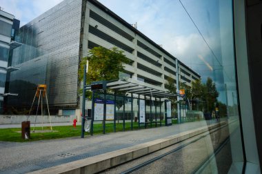 Toulouse, Fransa - Ekim 2020 - Blagnac Havaalanı 'nın çok katlı otoparkları, tramvay platformunda bekleyen sığınakları kapatıyor; terminal Tisso hafif tren hattının T2 hattı tarafından hizmet vermektedir.