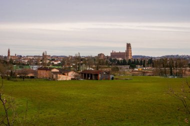 Güney Gotik UNESCO Dünya Mirası Alanı olan Sainte-Cecile 'in heybetli tuğla katedrali ve Madeleine Kilisesi, Fransa' nın piskoposluk şehri Albi 'yi çevreleyen yeşil bölge üzerinde hakimdir.