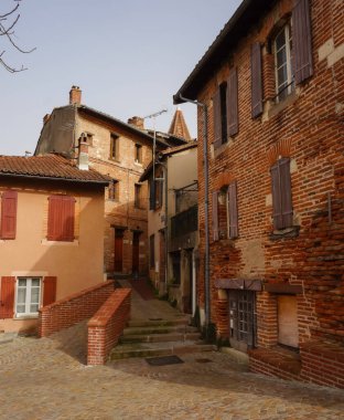 Tarihi bölgesi UNESCO Dünya Mirası Alanı olan Fransa 'nın Eski Episkopal Şehri Albi' de bir açık merdivenli, orta çağ kaldırımlı bir caddede geleneksel Güneyli tuğla evler.