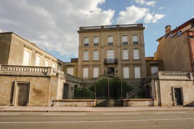 Hippolyte Savary Caddesi, Albi, Fransa - Aralık 2018 - Çatılarda balkon ve teraslarla donatılmış bir konağın ön cephesi ve merkezi bir balkon, kapılar ve metal portallarla korunan