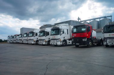 Mirandol-Bourgnounac, France - Sept. 2021 - Fleet of several semi-trailer trucks, side by side, in front of the grain silos of Caste Aliment, a producer of animal feed in the area of Carmaux clipart