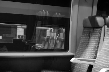 Bilinmeyen konum, Fransa - Ocak 2021 - Bombacı TER (Bölgesel Ekspres Treni) 'nin içinde ikinci sınıf koltuklar, bir başka trenin, Rgiolis TER' nin bulunduğu bir pencerenin yanında