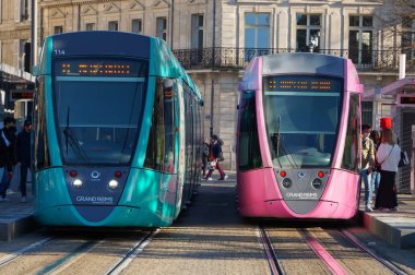 Reims, Fransa - Haziran 2021 - İki turkuaz ve pembe modern Alstom hafif tren yan yana, taşımacılık şirketi Citura tarafından işletiliyor, platformda, tren istasyonunun önünde (Gare Centre)