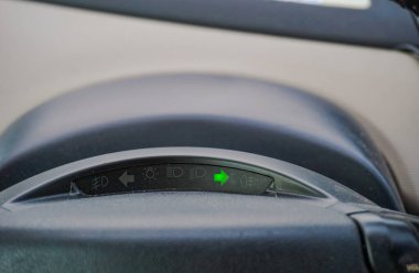 Tarn, Fransa - Ağustos 2020 - Fransa tarafından tasarlanmış 2010 Citroen C4 Picasso 'nun uyarı ışıkları, ok şeklindeki yön göstergesi (sağa dön işareti) açık, yeşil ışık arka planında.