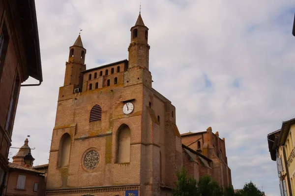 Fransa 'nın Rabastens kentindeki Ortaçağ Güney Gotik UNESCO Dünya Mirası Bölgesi Notre-Dame du Bourg' un görkemli kilisesinin genel görünümü, tuğla çan kulesine bir saat sabitlendi.