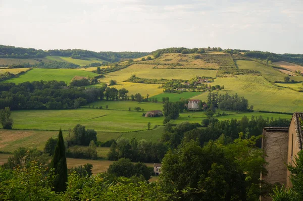Fransa 'nın güneyinde, Albi' nin tarım bölgesinde kırsal bir kasaba olan Cordes-sur-Ciel 'in surlarından görülebilen, yemyeşil, dağlık tarım arazisi.