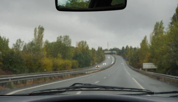 폭풍우가 운전하는 차량의 실드와 와이퍼의 표면에 빗물의 정밀한 보케에서 기울어지는 — 스톡 사진