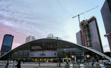 Paris, Fransa - 1 Temmuz 2019 - Yaya Esplanade de La Dfense boyunca CNIT ve gökdelenler, akşamları Paris İş Bölgesi 'nde bir vinç ile çevrili olan