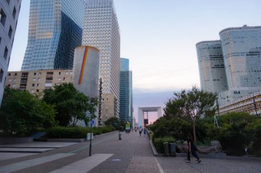 Paris, Fransa - Temmuz 2019 - La Defense İş Bölgesi 'nin Majunga, Ariane ve Coeur Savunma Kuleleri' nin (özellikle Majunga, Ariane ve Coeur Savunma Kuleleri) eteklerindeki yayalar ve yapraklı bir caddenin perspektifi