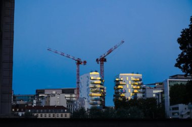 Paris, Fransa - Eylül 2020 - Bercy 'nin modern bölgesinde, iki kule vinç ve günbatımının yansımaları ile inşa halindeki gelecekteki yerleşim alanlarının gece görüşü 