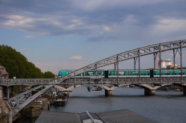 Paris, Fransa - Mayıs 2021 - Austerlitz Viaduct 'tan bir tren geçiyor, asma güvertesi olan bir köprü, 1904' te inşa edilmiş, beşinci metro hattının yükseltilmiş bir bölümünü destekliyor, Seine Nehri 'ni geçiyor.