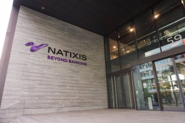 Paris, France - June 2021 - Glass entrance, logo and motto at the foot of the modern headquarters of the French bank Natixis (BPCE Group), in Paris-Rive Gauche financial district (13th arrondissement) clipart