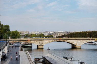 Paris, Fransa - Eylül 2022 - Sen Nehri 'ni geçen köprü Pont des Invalides; kıyılarda, Parisliler deniz ve tekneler üzerinde koşuyor veya geziniyor; Chaillot Sarayı çok uzakta görünüyor