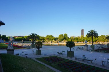 Paris, Fransa - Nisan 2021 - Lüksemburg Bahçeleri 'nin (Jardin du Lüksemburg) üzerindeki gün doğumu manzarası, Fransa Senatosu' nun parkı; Montparnasse Kulesi başkentin ufuk çizgisine hakim.