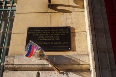 Paris, Fransa - Nisan 2021 - İkinci Dünya Savaşı sırasında Vichy Hükümeti 'nin yardımıyla Alman işgali altında sınır dışı edilen Yahudi öğrencilerin anısına Henri Lisesi' nin duvarındaki hatıra plakası