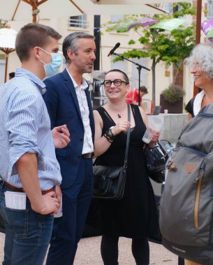 Toulouse, Fransa - 25 Haziran 2020 - Antoine Maurice, Archipel Citoyen 'in Toulouse belediye başkanlığı için ekolojist adayı, gülümseyen, kadın destekçilerle ve kampanya personelinin maskeli genç bir üyesiyle konuşuyor.