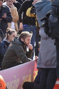 Paris, Fransa - Kasım 2022 - Paul Larrouturu, ünlü sosyalist televizyon kanalı LCI, Ulusal Meclis önünde düzenlenen aşırı sol gösteride bir eylemciyle röportaj yapmak için diz çöktü