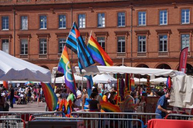 Toulouse, Fransa - 10 Haziran 2023 - Capitole Meydanı 'ndaki tuğla eteklerinde açık hava pazarı, renkli gökkuşağı LGBT bayraklarıyla (Fransızca 
