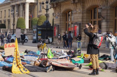 Reims, Fransa - Mart 2021 - Bayraklı ve tabelalı genç eylemciler, öğrencilerin iklim değişikliği ve küresel ısınmaya karşı gösterileri sırasında Vesle sokağındaki tramvay yollarını kapatın