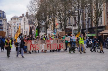 Reims, Fransa - Mart 2021 - Bayraklı ve tabelalı genç eylemciler, öğrencilerin iklim değişikliği ve küresel ısınmaya karşı gösterileri sırasında Vesle sokağındaki tramvay yollarını kapatın