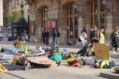 Reims, Fransa - Mart 2021 - Bayraklı ve tabelalı genç eylemciler, öğrencilerin iklim değişikliği ve küresel ısınmaya karşı gösterileri sırasında Vesle sokağındaki tramvay yollarını kapatın