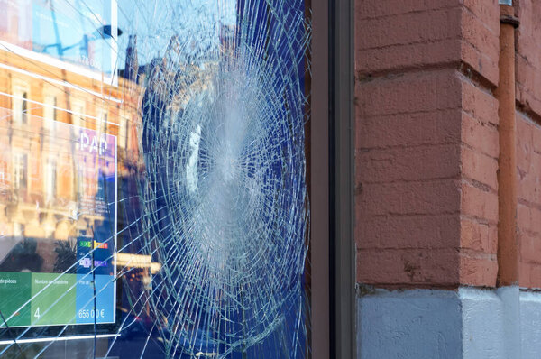 Toulouse, France - April 2023 - Scene of political violence: broken glass on a storefront in the city center, vandalized by far-left fringes amid social unrest over the government's pension reform