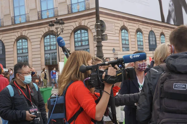 Paris, Fransa - 10 Ekim 2020 - Diğer meslektaşları arasında, Fransız Basın Ajansı 'ndan (AFP) bir kadın gazeteci, Marchons Enfants' in eylemlerinde dış mikrofonla donatılmış bir TV kamerası kullanıyor.