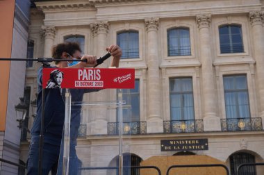 Paris, Fransa - 10 Ekim 2020 - Marchons Enfants personelinin bir üyesi, Adalet Bakanlığı önünde üreme yasasına karşı yapılan bir gösteriden sonra kürsünün mikrofonundan ayrıldı