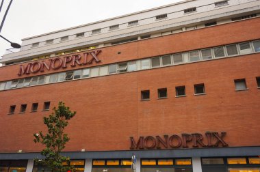 Toulouse, Fransa - Haziran 2021 - Kırmızı tuğla, büyük bir alışveriş caddesi olan Rue d 'Alsace-Lorraine' de büyük bir Monoprix mağazasının ön cephesi; Monoprix kentsel alanlarda faaliyet gösteren bir perakende mağazasıdır.