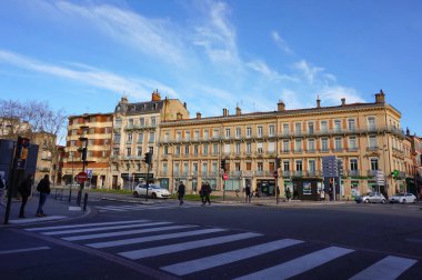 Toulouse, France - Jan. 2020 - Typical brick town buildings with local businesses on the ground floor, at the corner of four avenues : Metz, Francois Verdier, Carnot Boulevard and Frres Lion Streets clipart