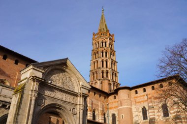 Toulouse, France - Jan. 2020 - The bell tower of the Basilica of Saint-Sernin, a medieval World Heritage Site and the largest romanesque church in Europe, in the perspective of Saint-Bernard Street