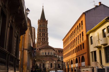 Toulouse, France - Jan. 2020 - The bell tower of the Basilica of Saint-Sernin, a medieval World Heritage Site and the largest romanesque church in Europe, in the perspective of Saint-Bernard Street