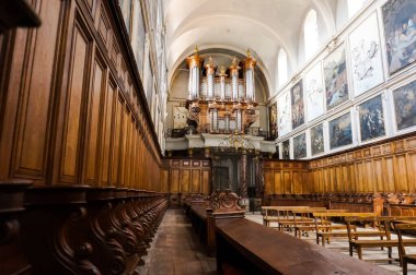 Toulouse, France - March 2020 - Paintings, benches and grandstand organ in the wooden choir stalls inside the baroque church of Saint-Pierre des Chartreux (Saint Peter of the Carthusian monastery)