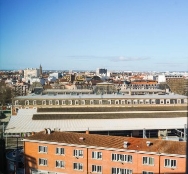 Güney Fransa 'nın Toulouse kentindeki Matabiau ve Marengo semtlerindeki eski tuğla binaların çatılarını süpüren tren istasyonu ön cephede ve Saint-Sernin Bazilikası uzakta.