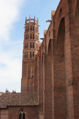 Fransa 'nın Toulouse kentindeki UNESCO Dünya Mirası bölgesi olan Saint Sernin Bazilikası' nın tuğla çan kulesinin transsept ve alçak açılı görüntüsünün yanı sıra Avrupa 'nın en büyük Romanesk kilisesi.