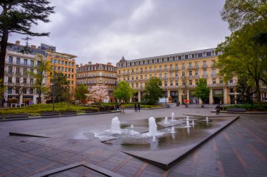 Toulouse, Fransa - Nisan 2019 - Charles de Gaulle Meydanı 'nda Capitole' un zengin ve köşe mahallelerinde Haussmann tarzı apartmanlarla çevrili su jetleri ve çeşmeler