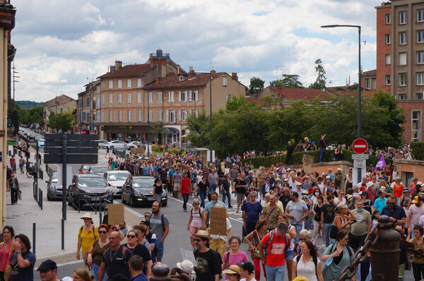 Albi, France - Aug. 14, 2021 - Crowd of protesters marching on Hippolyte Savary Street, at a demonstration against green passport, Covid-19 measures and vaccine mandate for healthcare workers