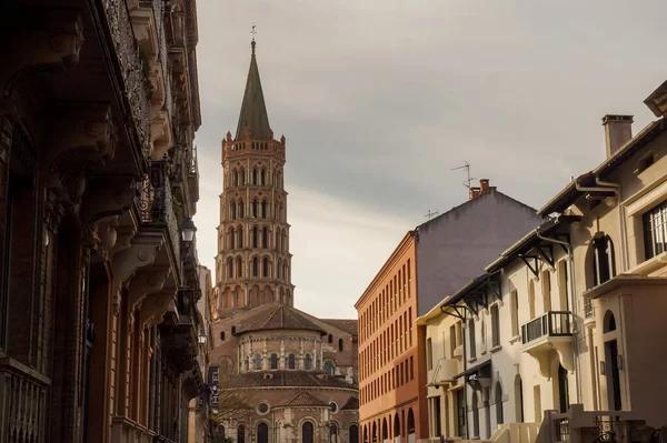 Toulouse, France - Jan. 2020 - The bell tower of the Basilica of Saint-Sernin, a medieval World Heritage Site and the largest romanesque church in Europe, in the perspective of Saint-Bernard Street
