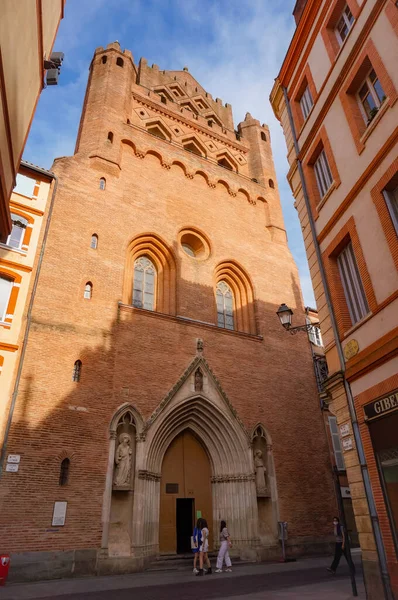 Perspective of Rue du Taur, a historical street in the centre of Toulouse, in the South of France, lined with old, traditional brick houses and towered by the bell-tower of Notre-Dame du Taur Church