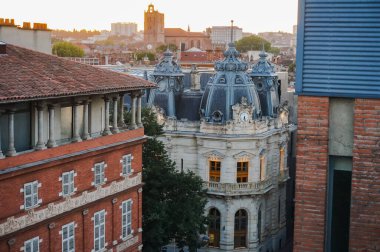 Toulouse, France - Feb. 2020 - Typical brick southern townhouses seen from the multi-storey car park in Place des Carmes, in the most expensive neighborhood of Toulouse, featuring old wooden shutters