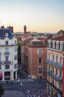 Toulouse, France - Feb. 2020 - Typical brick southern townhouses seen from the multi-storey car park in Place des Carmes, in the most expensive neighborhood of Toulouse, featuring old wooden shutters