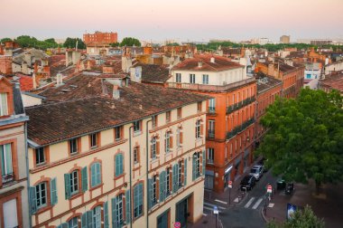 Elevated view over ancient, Southern-style town buildings, constructed in traditional brick on Rue Pharaon Street, in the historic neighborhood of Carmes, in the city center of Toulouse, France