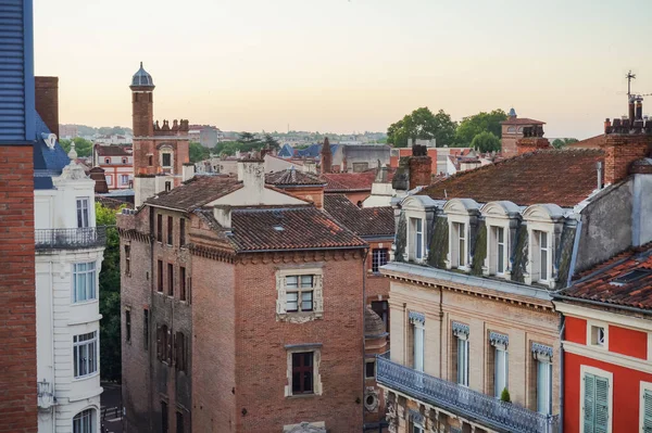 Elevated view over ancient, Southern-style town buildings, constructed in traditional brick on Rue Pharaon Street, in the historic neighborhood of Carmes, in the city center of Toulouse, France