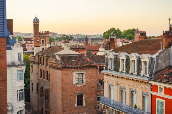 Elevated view over ancient, Southern-style town buildings, constructed in traditional brick on Rue Pharaon Street, in the historic neighborhood of Carmes, in the city center of Toulouse, France