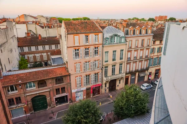 Toulouse, France - Feb. 2020 - Typical brick southern townhouses seen from the multi-storey car park in Place des Carmes, in the most expensive neighborhood of Toulouse, featuring old wooden shutters
